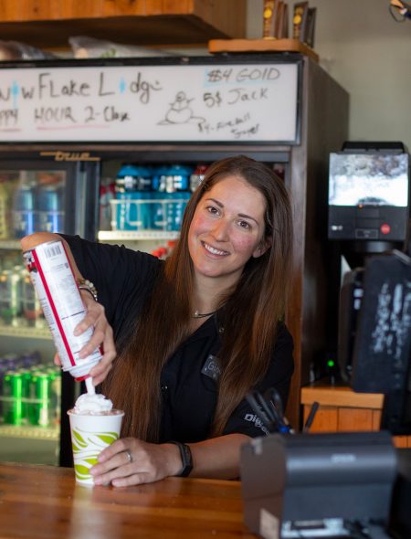 cashier putting on whipped cream on hot chocolate