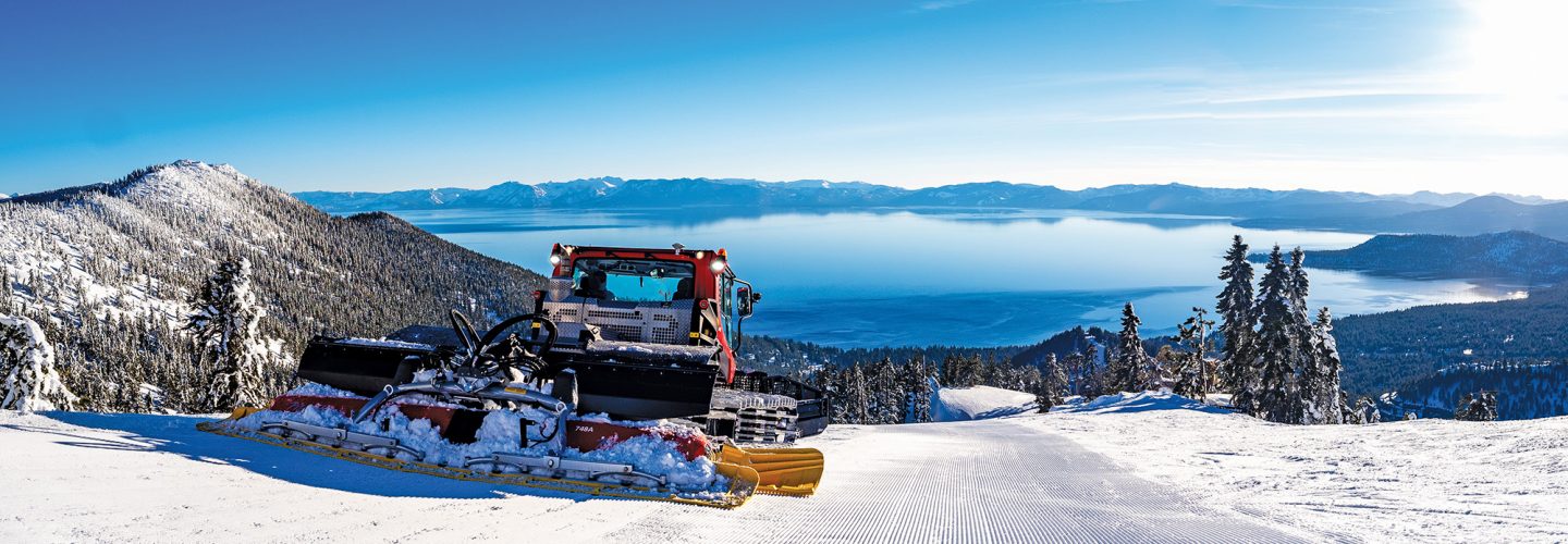 snow cat grooming skiing trail with views of lake tahoe