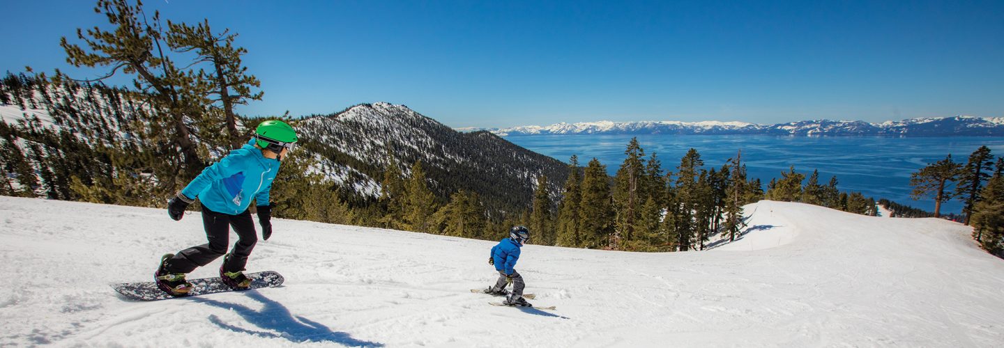 mom snowboards behind skier son with lake tahoe views at diamond peak