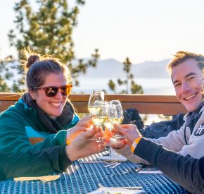 last tracks event group cheers wine glass with lake tahoe views