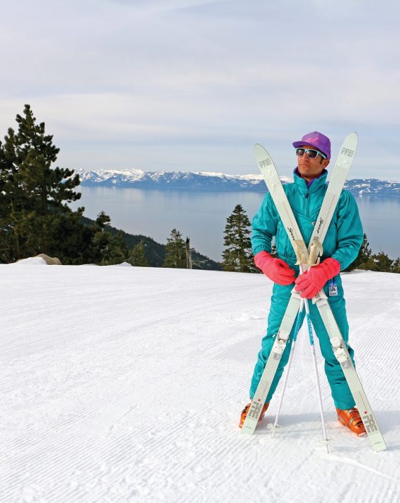 skier in teal retro ski onesie poses at the top of crystal ridge at diamond peak with lake tahoe views