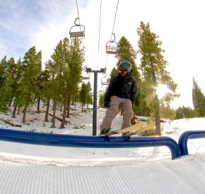 skier rides a rail in village terrain park