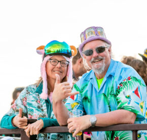 couple in tropical shirts poses on deck at diamond peak