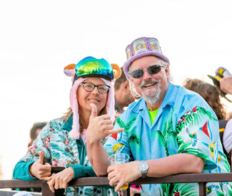 couple in tropical shirts poses on deck at diamond peak