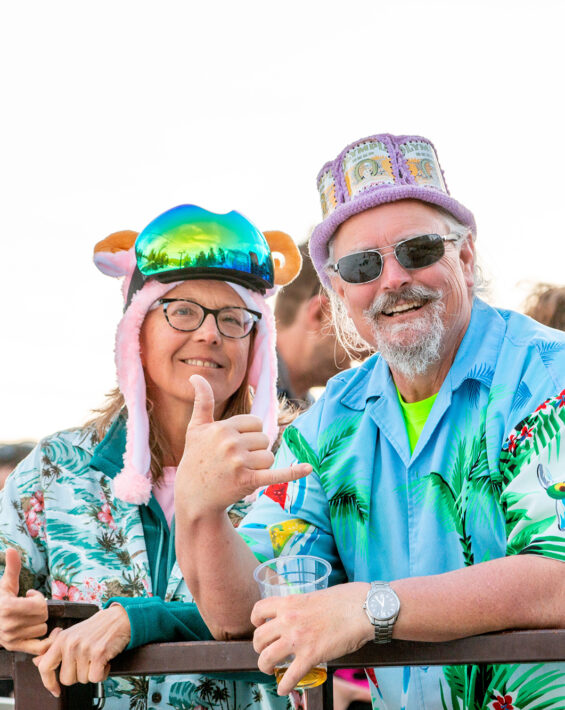 couple in tropical shirts poses on deck at diamond peak