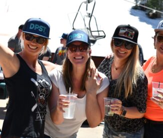 ladies on deck with ski team hats and drinks