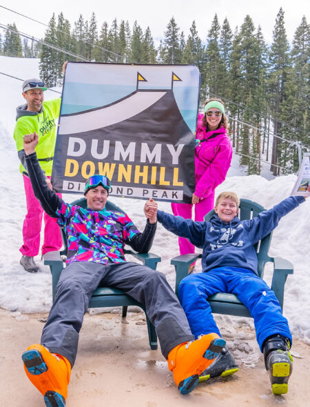 winners of dummy downhill pose with banner