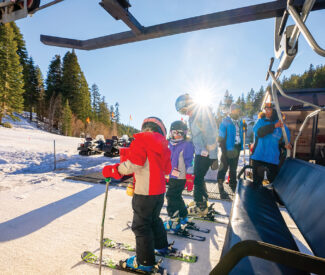 Lift operator loads skiers on chairlift