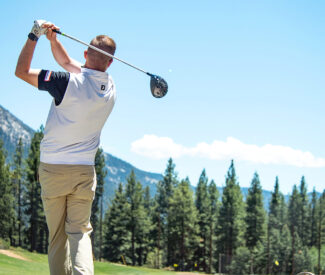 male golfer swings on driving range at Incline village championship golf course