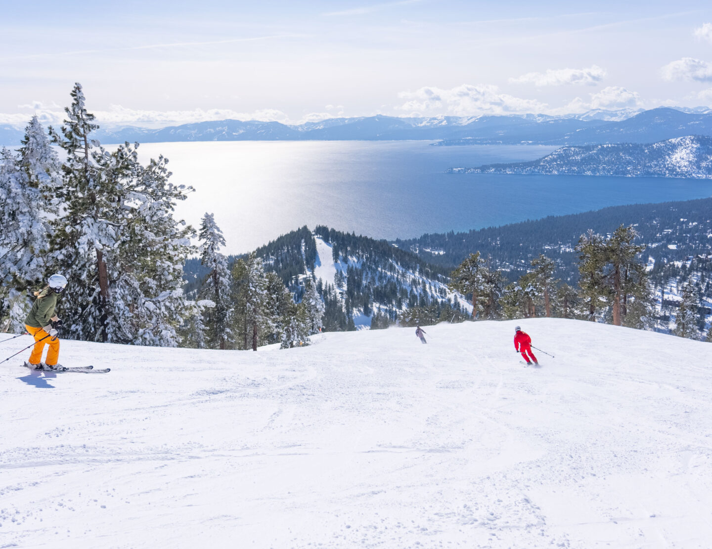 women ski down crystal ridge with lake tahoe views