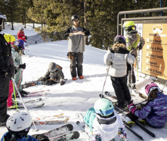 group of kids in front of terrain park safety sign for lesson
