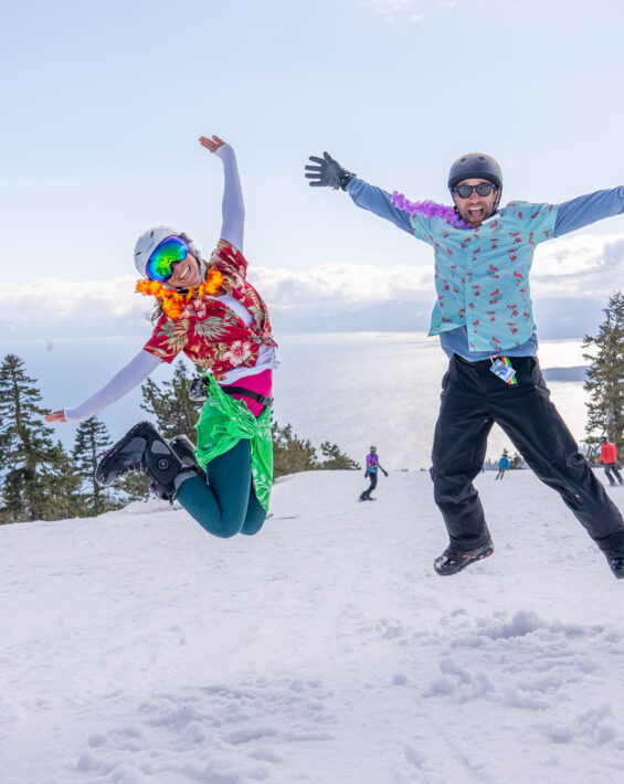 woman and man jump on top of mountain in tropical tees