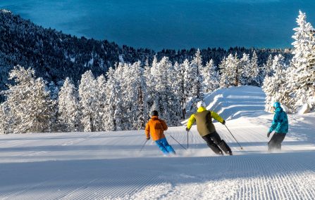 three skiers with views of Lake Tahoe