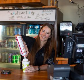 cashier putting on whipped cream on hot chocolate