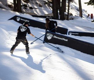 terrain park crew rakes near rails in village terrain park at diamond peak