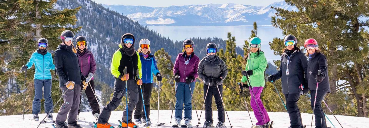 Group of skiers posing at the summit of Diamond Peak