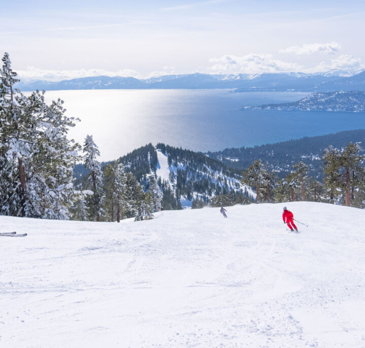 women ski down crystal ridge with lake tahoe views