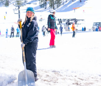 female employee shovels on snow