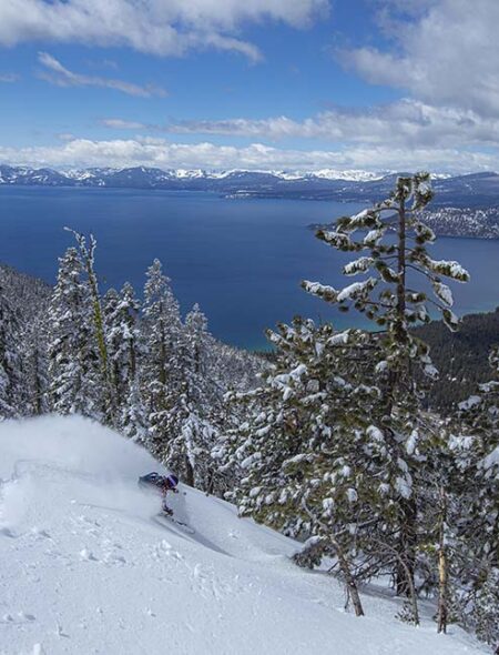Skier in deep powder with view of Lake Tahoe
