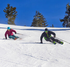 two skiers carving a groomer at diamond peak