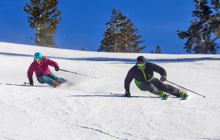 two skiers carving a groomer at diamond peak